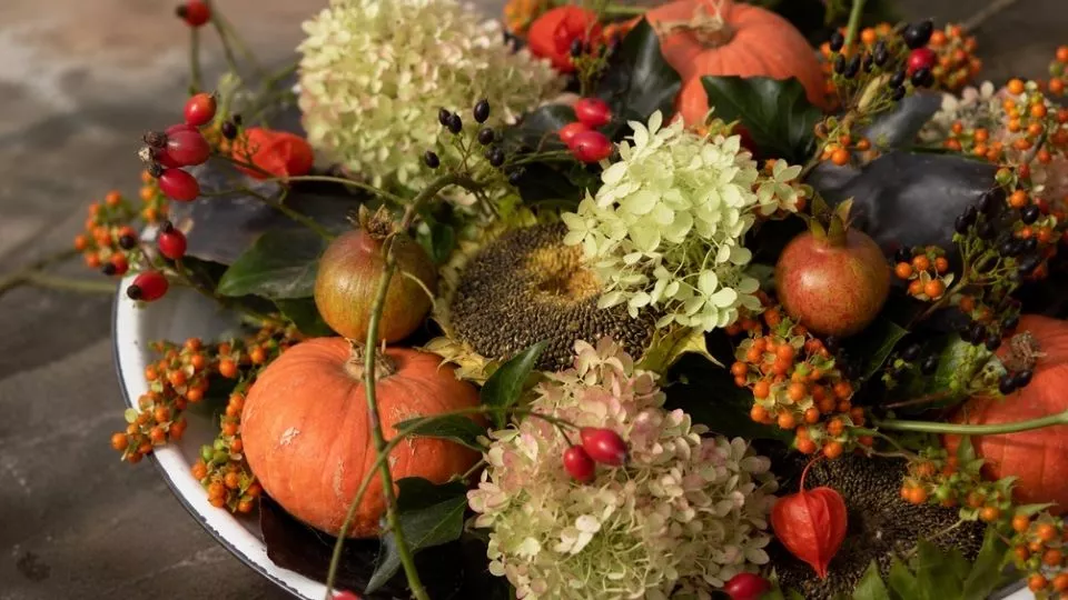 Afbeelding Herfst op een schaal: bloemstuk met pompoen, rozenbottels en bessen