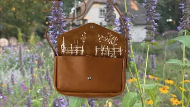 Winnen: leren tas met verborgen tuinprint