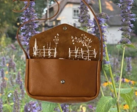 Winnen: leren tas met verborgen tuinprint