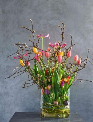 Een royale lentevaas met tulpen, magnolia en nerine
